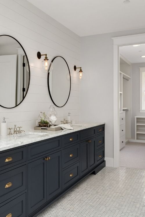 Bathroom in New Luxury Home with Two Sinks and Dark Blue Cabinets. Shows Walk-In Closet
