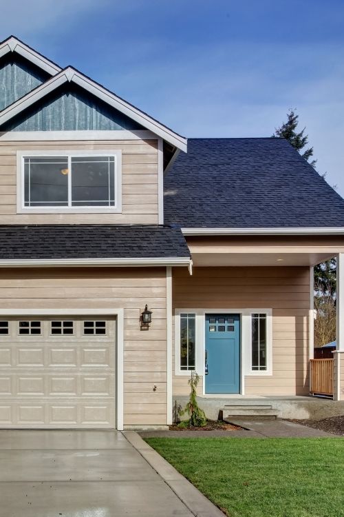 House exterior. American beige house with green grass.