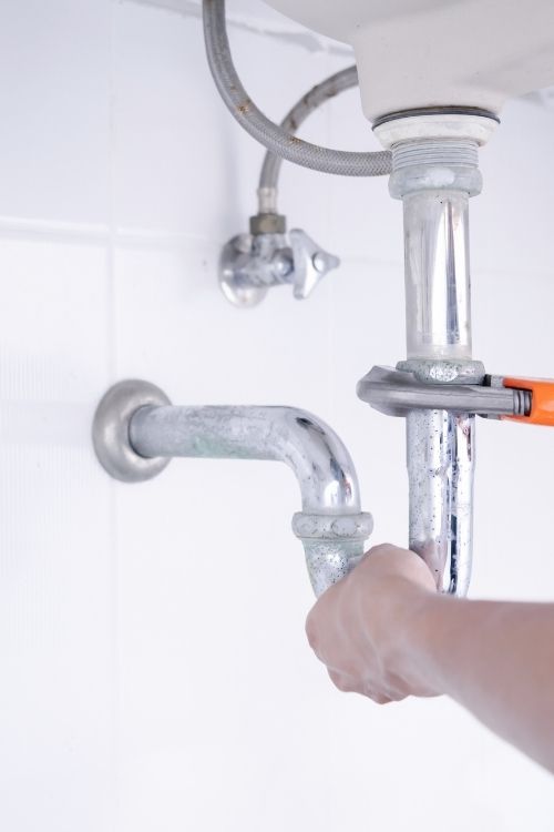 Plumber working in the bathroom, plumbing repair service.